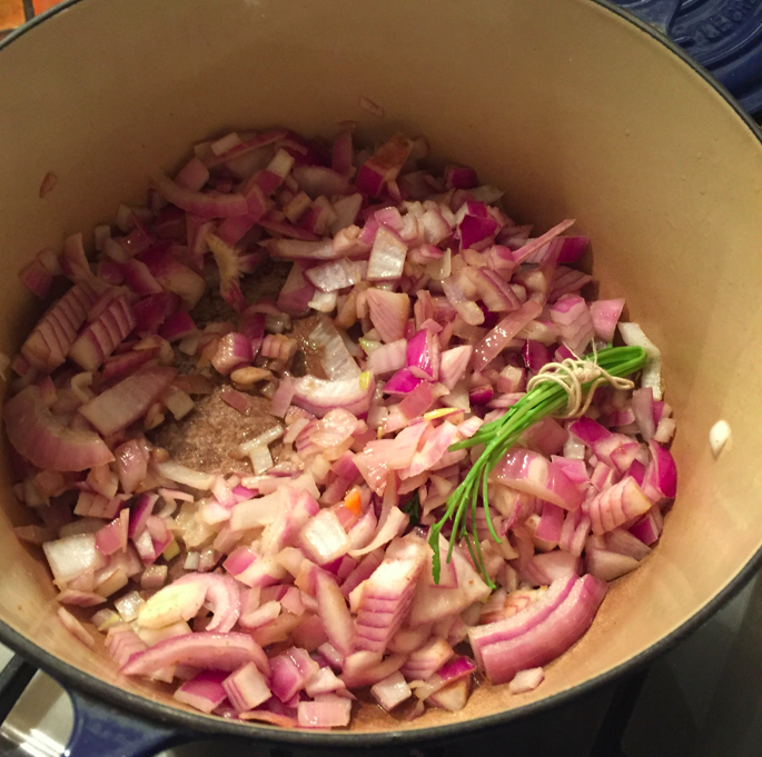 In pot with the hot olive oil, place the diced red onions, cumin, and cilantro sprigs. Mix together on medium heat for 10 minutes.