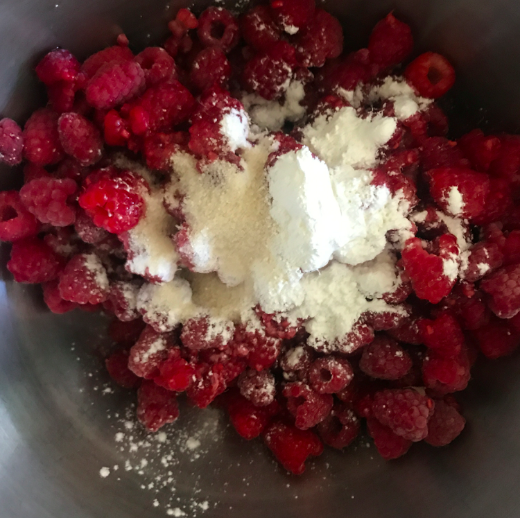 Coat the raspberries with cornstarch and mix it all around. Sprinkle some sugar on the raspberries too. 